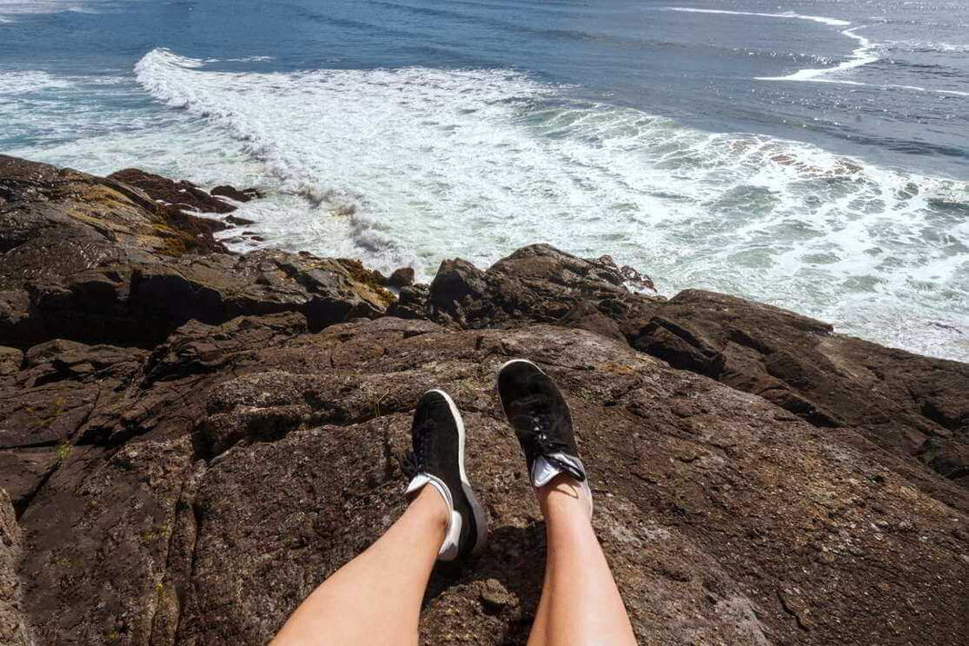 Chaussettes invisibles et baskets en vacances sur les rochers en bord de mer.